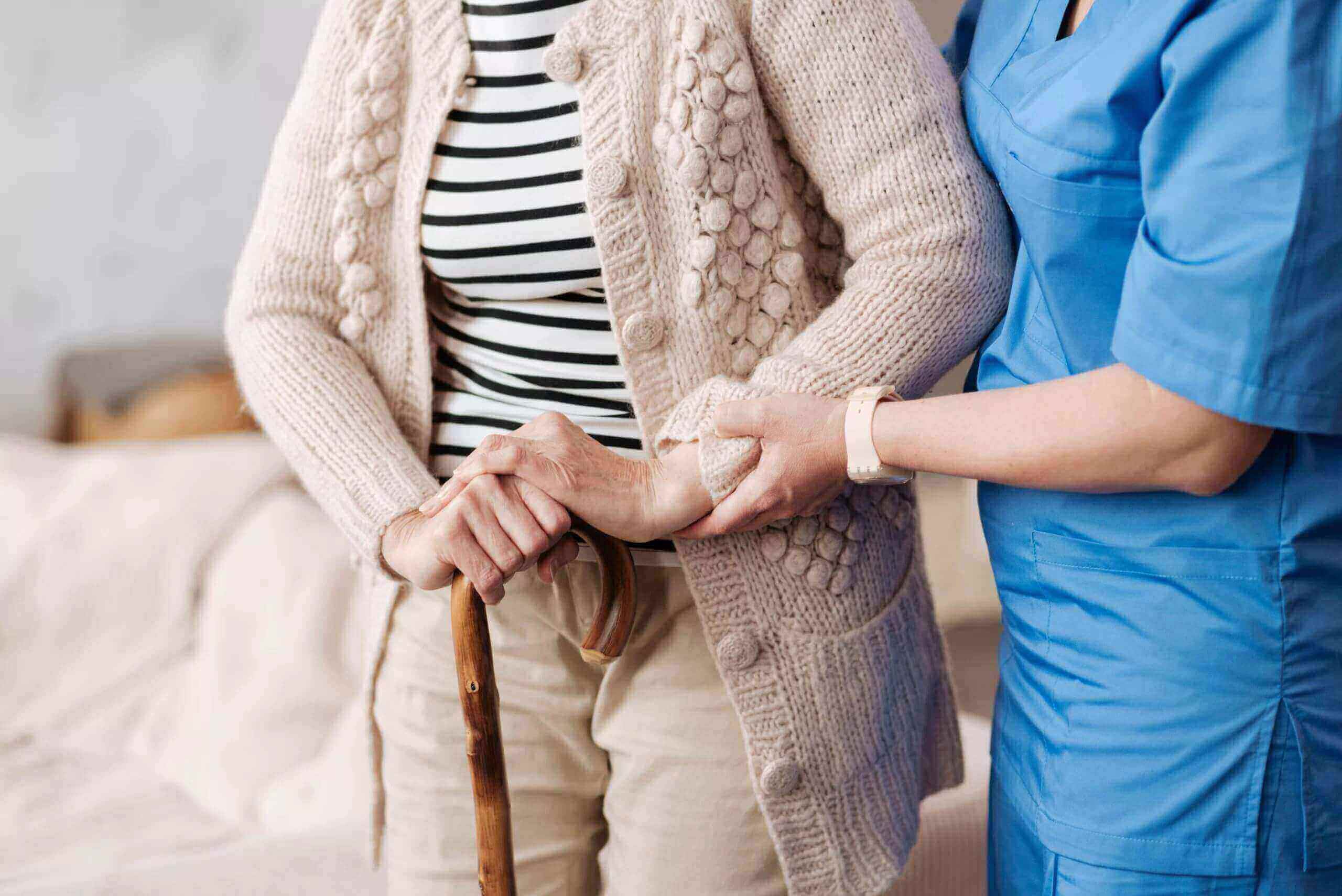 An elderly lady being helped by a nurse