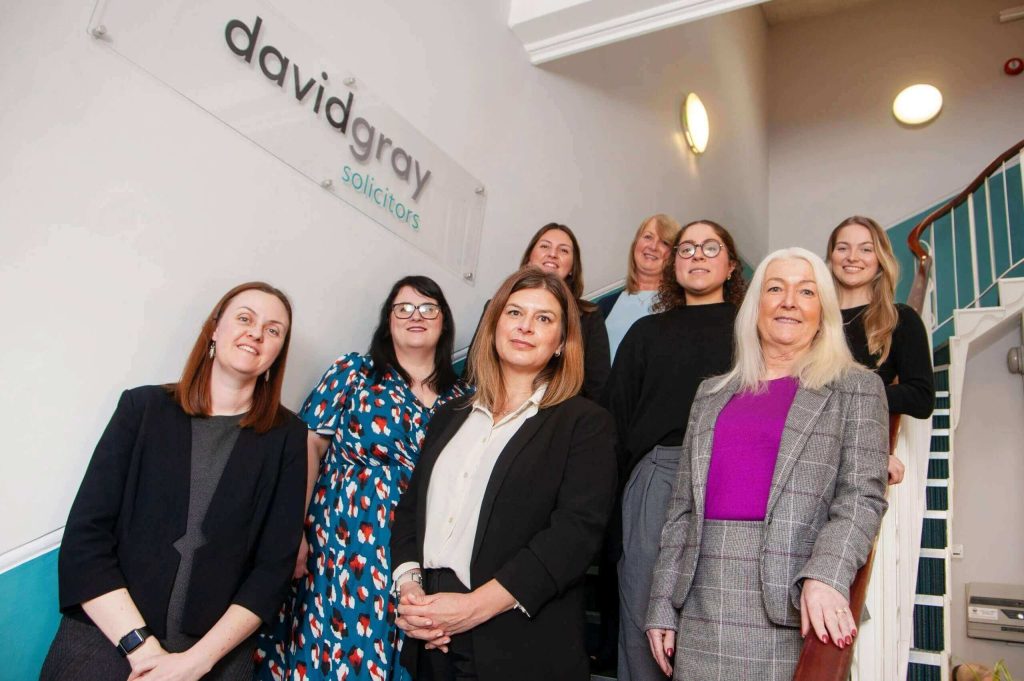 The David Gray Court of Protection team posing for a photo on a flight of stairs